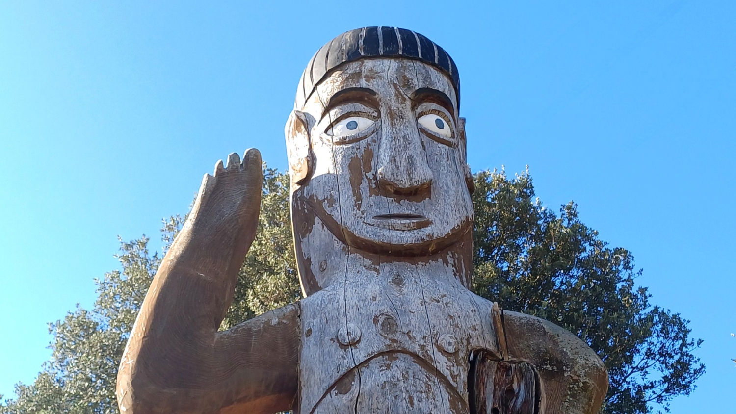 Tótem de madera en actitud gestual.