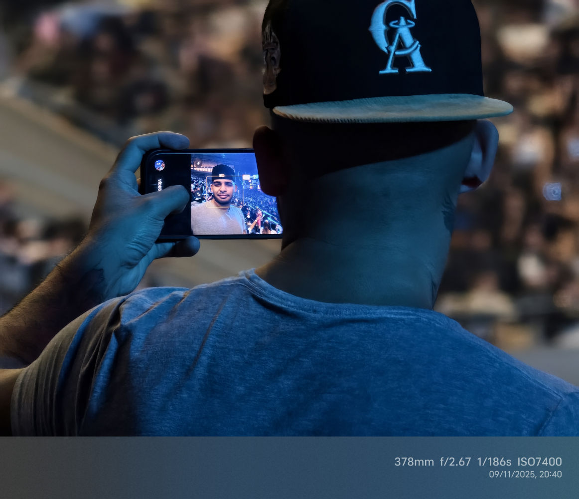 Detalle de un espectador haciéndose un selfie.