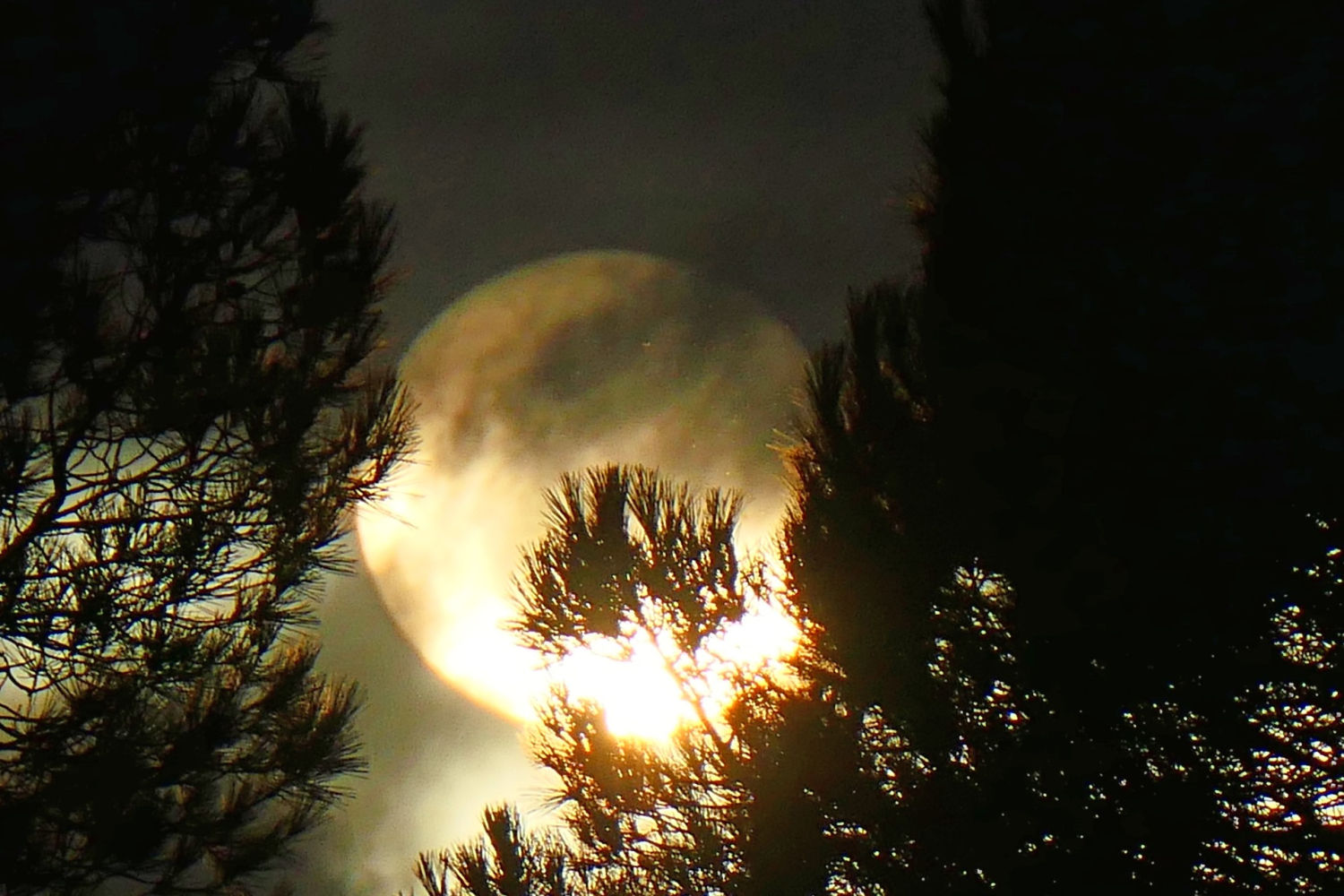 El sol blanco medio tapado por las nubes.