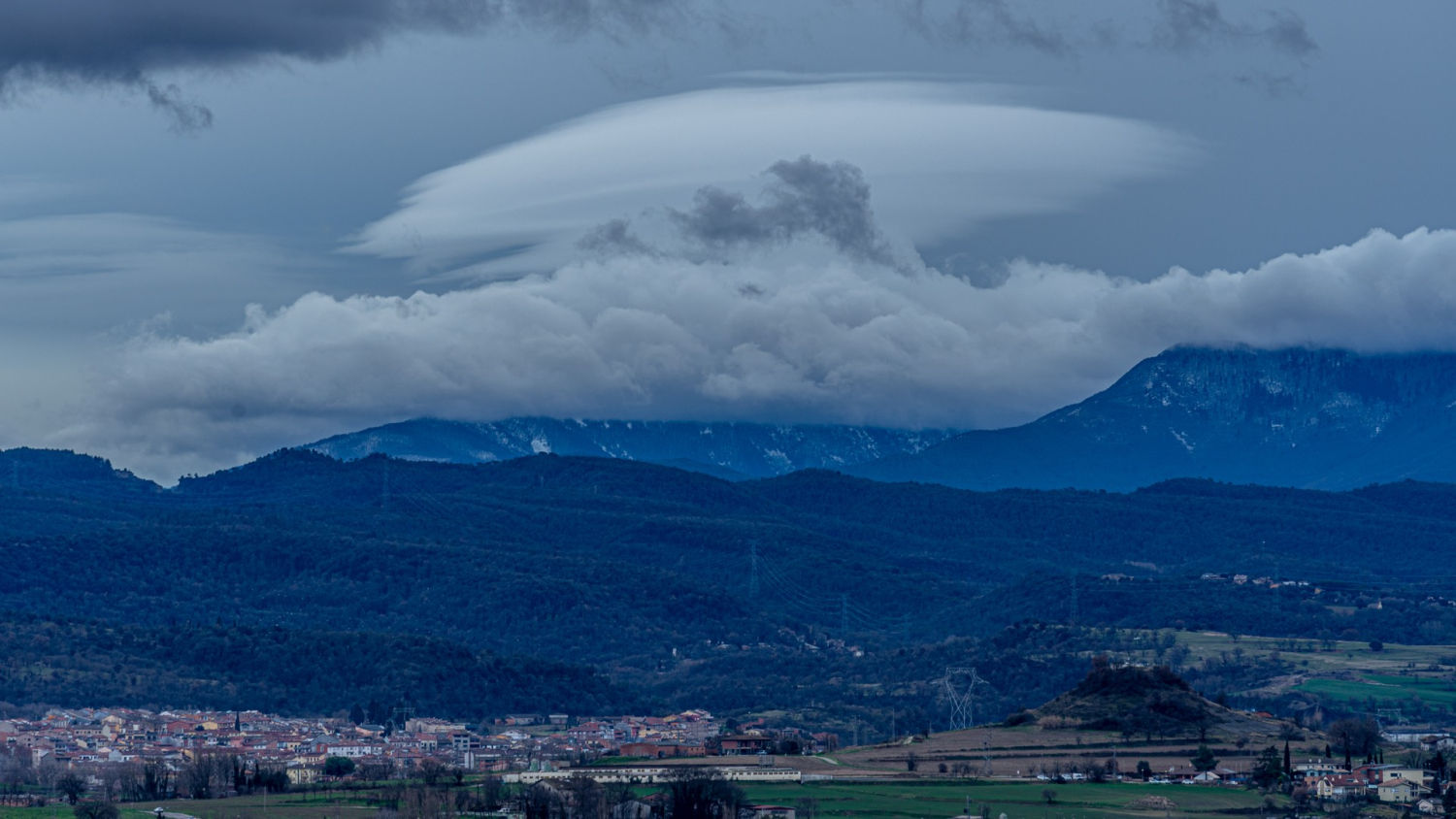 Nubes lenticulares sobre las montañas y la población de Manlleu, en Osona.