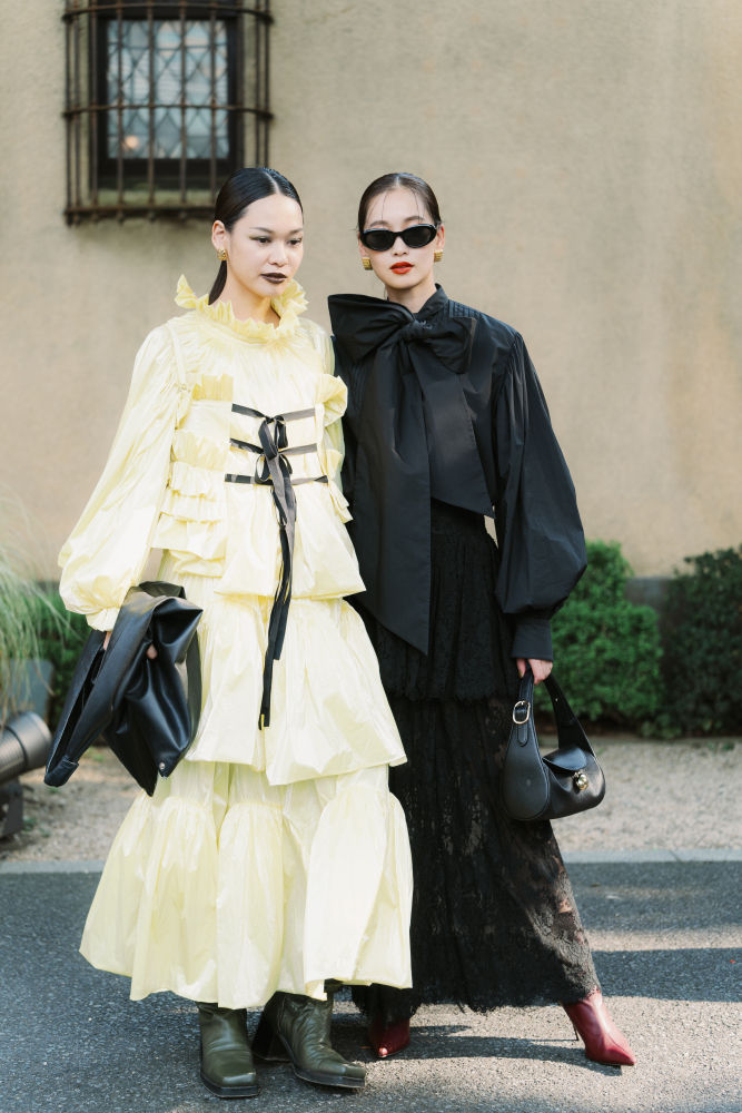 TOKYO, JAPAN - SEPTEMBER 06: Ami and Aya are seen wearing (L) black mini dress, blue tights, black shoes, green handbag; (R) black long dress, blue tights, black shoes, rose handbag during Rakuten Tokyo Fashion Week S/S 2025 on September 06, 2024 in Tokyo, Japan. (Photo by Mila Gruber/Getty Images)