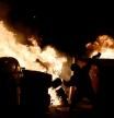 A protester throws a stone to Catalan regional police force Mossos d'Esquadra as dustbins burn in flames during a demonstration against the imprisonment of Spanish rapper Pablo Hasel in Barcelona on February 18, 2021. - Dozens of people were arrested in Spain after a second night of clashes over the jailing of a rapper for controversial tweets, triggering a political backlash. Angry demonstrations first erupted on February 16 night after police detained Pablo Hasel, 32, who was holed up in a university in Catalonia to avoid going to jail in a highly contentious free speech cas e. (Photo by Josep LAGO / AFP)