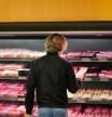 Un hombre en la sección de carne del supermercado