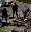 FILE PHOTO: A cemetery worker uses a cross to even out the soil at the Flores cemetery, amid the outbreak of the coronavirus disease (COVID-19) in Buenos Aires, Argentina April 21, 2021. REUTERS/Agustin Marcarian/File Photo