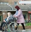 Una mujer pasea a una anciana en silla de ruedas, en las inmediaciones de la residencia geriátrica de As Gándaras para visitar a un familiar, a17 de abril de 2021, en Lugo, Galicia (España). Una de las nuevas medidas incluidas en la desescalada de Galicia consiste en la ampliación de las posibilidades de visita a cualquier persona en una residencia geriátrica, con cita previa. También se amplían las salidas de las residencias a tres veces por semana y con una duración de cuatro horas cada una de estas tres veces. Otro de los cambios en las restricciones incluye el retraso del toque de queda a las 23.00 horas. Además, los restaurantes podrán cerrar a esa misma hora. 17 ABRIL 2021;RESIDENCIAS;RESIDENCIAS GERIÁTRICAS;ANCIANOS Carlos Castro / Europa Press 17/04/2021