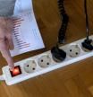 Una persona apaga una regleta para ahorrar electricidad