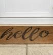 Alfombra de bienvenida dice Hola por una puerta principal