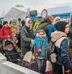 Ukrainian evacuees queue as they wait for further transport at the Medyka border crossing, after they crossed the Ukrainian-Polish border, southeastern Poland, on March 29, 2022, on the 34th day of the Russian invasion of Ukraine. - Ukraine is calling for an 