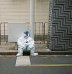 A worker in protective suit rests on a street during a lockdown, amid the coronavirus disease (COVID-19) pandemic, in Shanghai, China, April 16, 2022. REUTERS/Aly Song