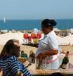 Sector turístico. Ambiente de trabajo en el sector turístico con camareros en la zona de playa de la Barceloneta. Hostelería, temporalidad