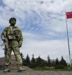 A Russian soldier guards an area at the Alley of Glory exploits of the heroes - natives of the Kherson region, who took part in the liberation of the region from the Nazi invaders in Kherson, Kherson region, south Ukraine, Friday, May 20, 2022, with a replica of the Victory banner marking the 77th anniversary of the end of World War II right in the background. The Kherson region has been under control of the Russian forces since the early days of the Russian military action in Ukraine. This photo was taken during a trip organized by the Russian Ministry of Defense. (AP Photo)
