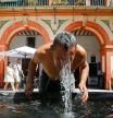 -FOTODELDÍA- GRAFAND2186. CÓRDOBA, 03/08/2022.- Un hombre se refresca en la fuente de la plaza de la Corredera de Córdoba cuando se cumple hoy miércoles el quinto día de la tercera ola de calor del verano con máximas que de nuevo rondarán los 40 grados en la zona centro, e incluso los superarán en buena parte de Extremadura y del valle del Guadalquivir. EFE/Salas