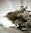 A sepia toned vintage steam locomotive begins it's journey from the station