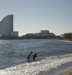 Una pareja se baña en la playa de la Barceloneta, a 25 de diciembre de 2022, en Barcelona