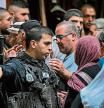 An Israeli policeman argues with a woman as Muslim worshippers are denied entry to the Aqsa mosque compound in the old city of Jerusalem on October 27, 2023, ahead of demonstrations in solidarity with Palestinians in the Gaza Strip amid the ongoing fighting between Israel and the Hamas movement. (Photo by Yuri CORTEZ / AFP)