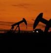 A truck drives past oil pump jacks at dusk near Karnes City, Texas, Wednesday, Nov. 1, 2023, . (AP Photo/Eric Gay)