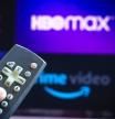 BRAZIL - 2021/06/03: In this photo illustration a close-up of a hand holding a TV remote control seen displayed in front of the Netflix, HBO Max and Prime Video logo. (Photo Illustration by Rafael Henrique/SOPA Images/LightRocket via Getty Images)