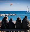 foto XAVIER CERVERA 07/01/2024 escollera espigon d la playa la mar bella, barcelona, al fondo izquierda, y mas en primer termino, ciudadanos o turistas en la playa d bogatell observan un velero, cometa, windsurfistas,.. (en el mar, por esta zona, se ubicara l inauguracion de la copa america)