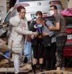 People assist a woman reacting to devastation from deadly floods in Sedavi, south of Valencia, eastern Spain, on November 2, 2024. Rescuers have raised the death toll in Spain's worst floods for a generation to 205 and fears grew for the dozens missing as hopes of finding survivors fade. (Photo by Manaure QUINTERO / AFP)