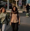 Women cross an intersection in downtown Tehran, Iran, Thursday, Nov. 20, 2025. (AP Photo/Vahid Salemi)