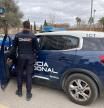 Un agente de la Policía Nacional junto a un coche oficial.
