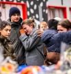 TOPSHOT - Mourners gather near the bar Le Constellation where a fire ripped through the venue during New Year's celebrations in the Alpine ski resort town of Crans-Montana killing around 40 people and injuring more than 100 others, in Crans-Montana on January 2, 2026. Investigators raced on January 2, 2026 to identify the victims of a fire that ripped through a bar in the Swiss Alps town of Crans-Montana, turning a New Year's celebration into one of the country's worst tragedies. Frederic Gisler, police commander in the Wallis canton in southwestern Switzerland, told reporters that authorities had counted 