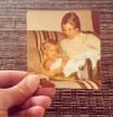 FOTOS HIJOS Hand holding an old photo of mother with new baby.