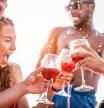 Happy friends drinking sangria wine at exclusive boat party - Young people having fun in summer vacation - Focus on left man hand glass - Travel, friendship, holidays and youth lifestyle concept