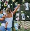 Victoria Mayer and her son Antonio visit a makeshift memorial at site of a collapsed building in Surfside, Florida, north of Miami Beach,on June 26, 2021. Victoria said she has lived in Surfside for two years and is originally from Argentina. - An engineer warned of 