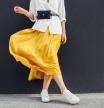 Mujer con camisa blanca, bolso riñonera y falda amarilla.