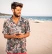 Hombre con camisa en la playa.