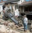 FILE - In this file photo dated Monday, July 19, 2021, a woman looks at cars and homes damaged after torrential rain caused flooding in Liege, Belgium. A new massive United Nations science report is scheduled for release Monday Aug. 9, 2021, reporting on the impact of global warming due to humans. (AP Photo/Valentin Bianchi, FILE)