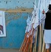 An Afghan man checks the Taliban flags kept for sale next to a poster of Taliban leader Mullah Abdul Ghani Baradar along a street in Kabul on August 27, 2021, following the Taliban's military takeover of Afghanistan. (Photo by Aamir QURESHI / AFP)