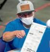 FILE - In this May 6, 2021, file photo, Maricopa County ballots cast in the 2020 general election are examined and recounted by contractors working for Florida-based company, Cyber Ninjas, at Veterans Memorial Coliseum in Phoenix. Cyber Ninjas, the inexperienced contractor hired to run a partisan review of the 2020 election on behalf of Republicans in the Arizona Senate, is scheduled to present its findings to top GOP lawmakers on Friday, Sept. 24, 2021. Election experts say the review, funded almost entirely by supporters of former President Donald Trump who have promoted false claims of fraud, was beset by problems and incompetence. (AP Photo/Matt York, Pool)