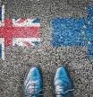 Brexit, flags of the United Kingdom and the European Union on asphalt road with legs