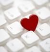 Small red heart on computer keyboard. Internet dating concept.