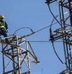 Un operario trabaja en una torre de alta tensión