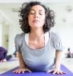 Mature women stretching in the fitness center. Mid adult female practicing the cobra pose during their yoga class in a gym.