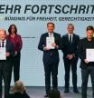 Designated German Chancellor Olaf Scholz of the Social Democratic Party (SPD), Christian Lindner of the Free Democratic Party (FDP) and Robert Habeck of Germany's Green Party hold signed copies of a coalition government agreement at the 