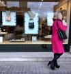 foto XAVIER CERVERA 12/03/2021 una mujer con abrigo fucsia magenta y un mobil rosa observa un escaparate d una tienda con bolsos para un hipotetico consumo o simplemente mirar ,shop en plaza francesc macia ,barcelona