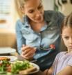 Una madre con una niña que no quiere comer