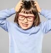 Niña con piojos rascándose la cabeza