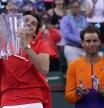 Taylor Fritz holds up his trophy after defeating Rafael Nadal, of Spain, behind at right, after the men’s singles finals at the BNP Paribas Open tennis tournament Sunday, March 20, 2022, in Indian Wells, Calif. Fritz won 6-3, 7-6. (AP Photo/Mark J. Terrill)