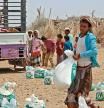 Yemenis displaced by the conflict, receive food aid and supplies to meet their basic needs, at a camp in Hays district in the war-ravaged western province of Hodeidah on March 29, 2022, as food prices have doubled since last year and the fact that Ukraine supplies nearly a third of Yemen's wheat imports has heightened fears of a deepening famine. - The disruption in export flows resulting from Russia's invasion and international sanctions has spurred fears of a global hunger crisis, especially across the Middle East and Africa, where the knock-on effects are already playing out. The toll is most evident in conflict zones such as Yemen, the Arab world's poorest, where a devastating war since 2014 has sparked one of the world's worst humanitarian crises. (Photo by Khaled Ziad / AFP)