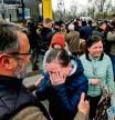 People fleeing fighting in the southern city of Mariupol meet with relatives and frieds as they arrive in a small convoy that crossed through territory held by Russian forces, after the opening of a humanitarian corridor, at a registration center for internally displaced people in Zaporizhzhia on April 21, 2022. (Photo by Ed JONES / AFP)
