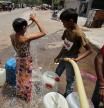 A boy bathes as he waits to collect water from a municipal tanker on a hot summer day in New Delhi, India, May 1, 2022. REUTERS/Anushree Fadnavis