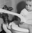 Un niño empleando el inodoro en los años cincuenta