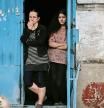 Women stand at the door of their apartment building in the city of Lysychansk, a city without electricity and water, in the eastern Ukrainian region of Donbas, on May 26, 2022. - Ukraine said may 26 the war in the east of the country had hit its fiercest level yet as it urged Western allies to match words with support against invading Russian forces. Moscow's troops are pushing into the industrial Donbas region after failing to take the capital Kyiv, closing in on several urban centres including the strategically located Severodonetsk and Lysychansk. (Photo by ARIS MESSINIS / AFP)