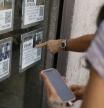 Unas personas se paran delante del escaparate de una inmobiliaria que publicita los inmuebles que gestiona, este lunes en el centro de Madrid