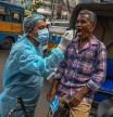 TOPSHOT - Health workers collect swab samples from commuters for Covid-19 coronavirus screening after a surge in number infections in Kolkata on July 4, 2022. (Photo by DIBYANGSHU SARKAR / AFP)